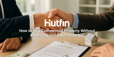 Two professionals shaking hands over a real estate contract, keys, and cash on a desk, symbolizing a confident all-cash commercial property deal.