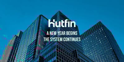 Modern glass office towers viewed from below against a clear blue sky, symbolizing stability and continuity in commercial real estate.