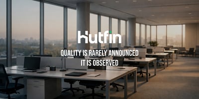 Empty modern office with rows of desks and large windows overlooking a city, conveying quiet order and intentional design.