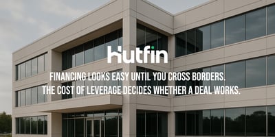 A modern mid-rise commercial office building with large reflective windows and clean architectural lines, photographed on an overcast day.