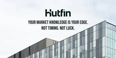 A modern commercial office building with a sleek grid of glass and metal panels, photographed against an overcast sky, showcasing contemporary architectural design.