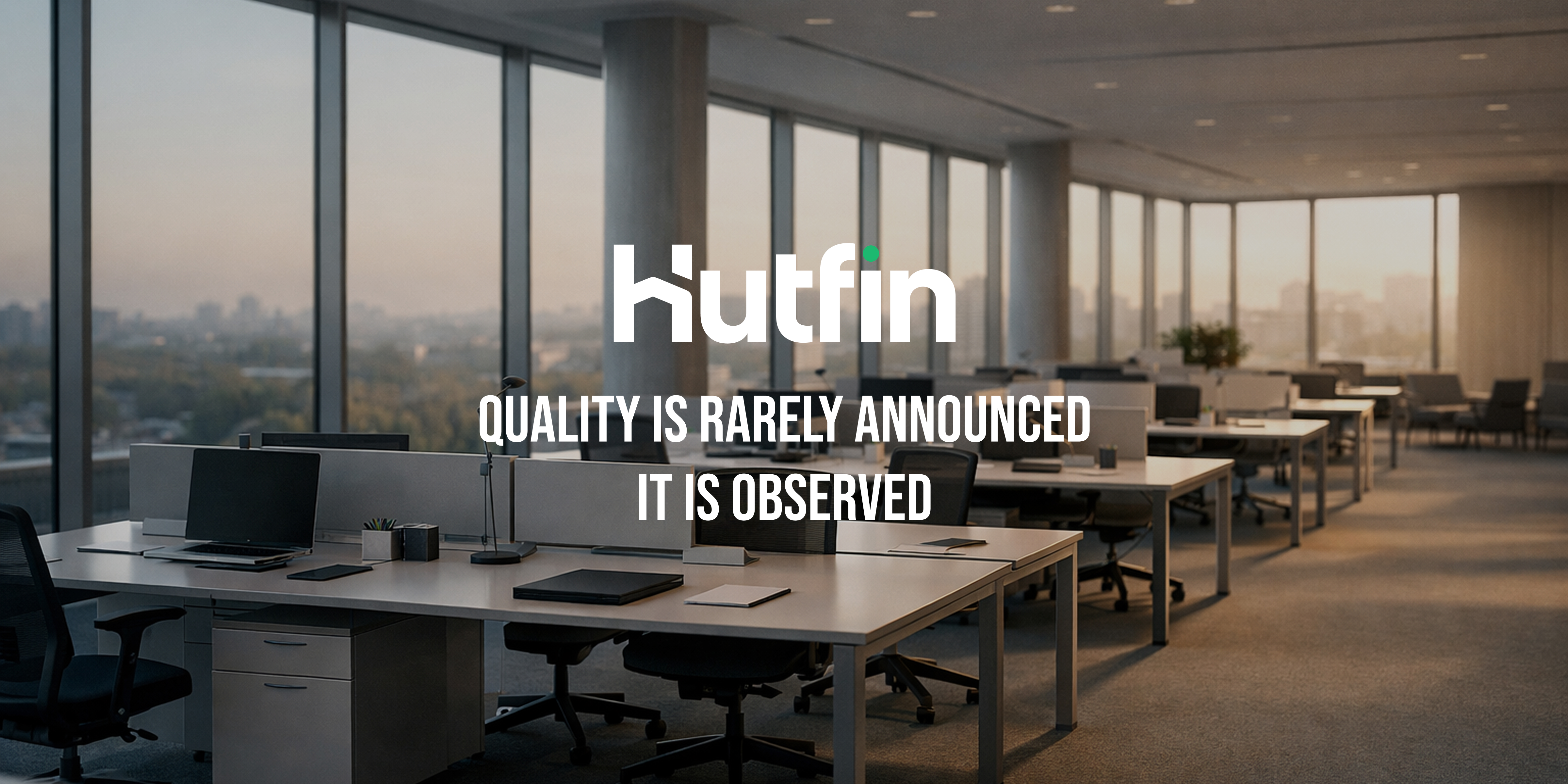 Empty modern office with rows of desks and large windows overlooking a city, conveying quiet order and intentional design.