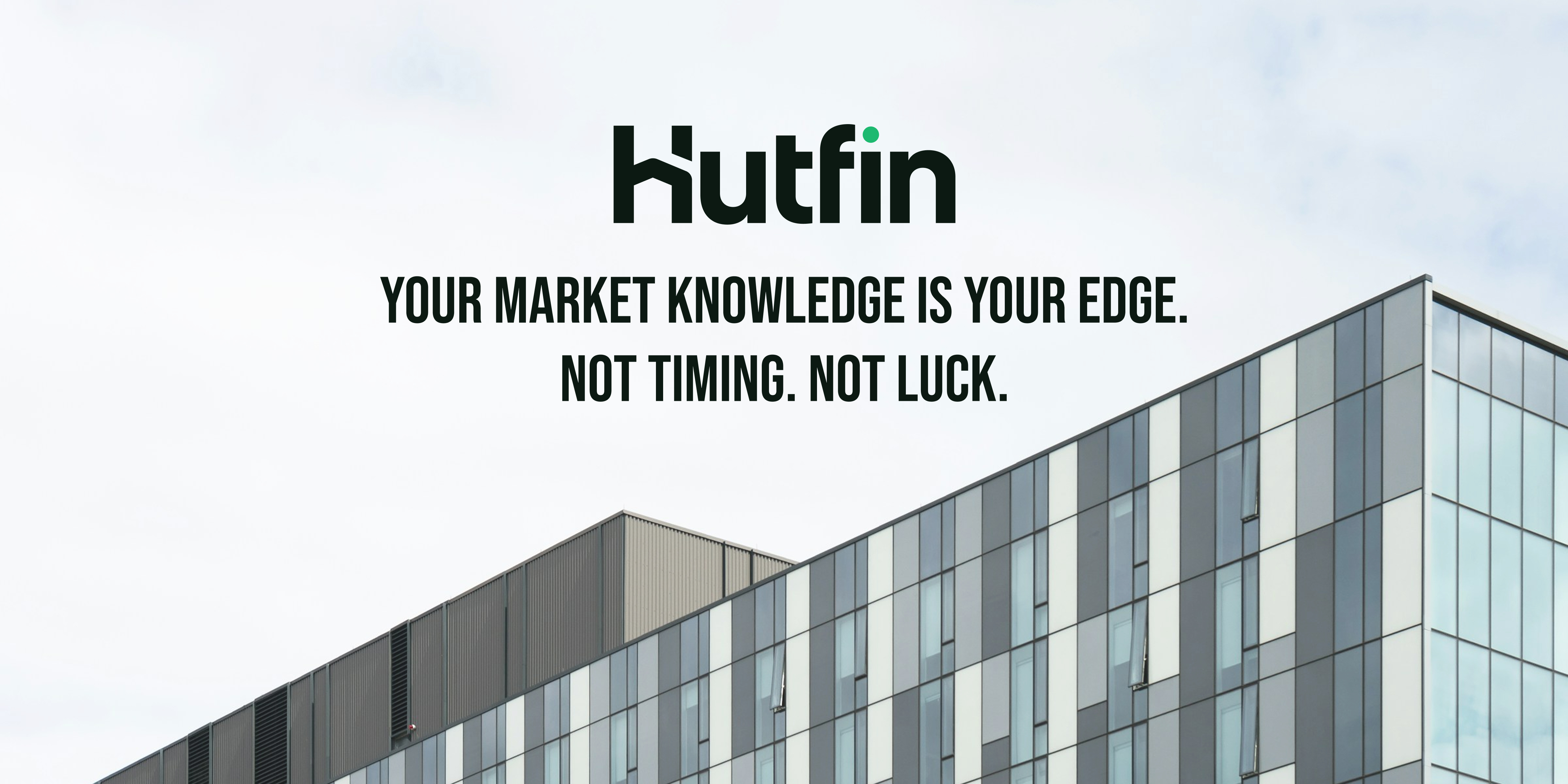 A modern commercial office building with a sleek grid of glass and metal panels, photographed against an overcast sky, showcasing contemporary architectural design.